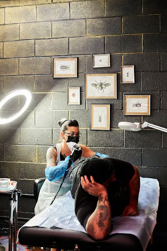 Tattoo artist working at a private station inside Strata