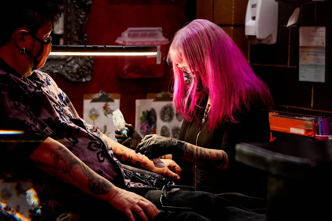 Independent tattoo artist working with a client at Strata